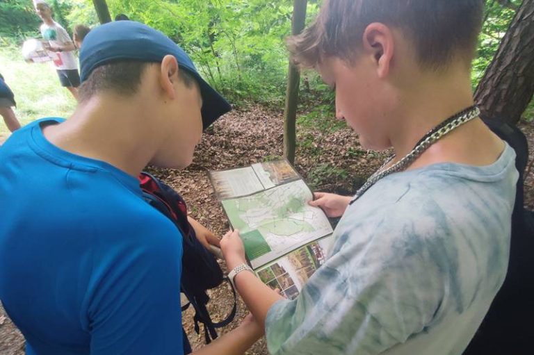 Młodzi uczestnicy leśnego rajdu pieszego analizują mapę
