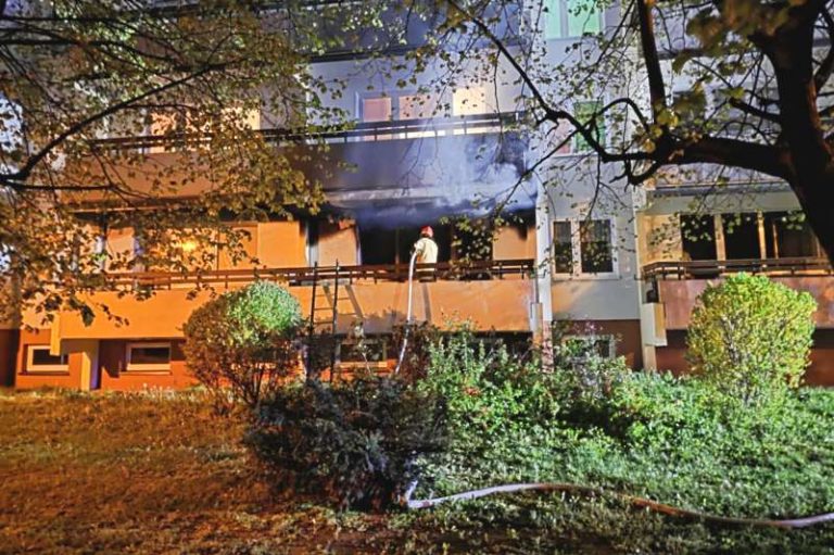 Turek. Pożar w bloku na ul. Milewskiego. Strażak na balkonie gasi pożar