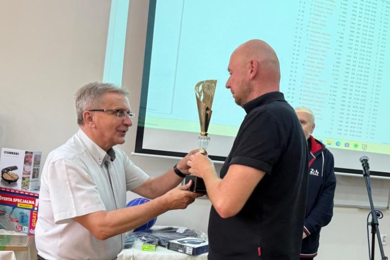 Zdzisław Jezierski, prezes Sm Tęcza w Turku wręcza puchar Oskarowi Włodarczykowi