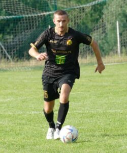 Dawid Jóźwiak Show! Dawid Jóźwiak (Grom Malanów) biegnie z piłką po zielonej murawie